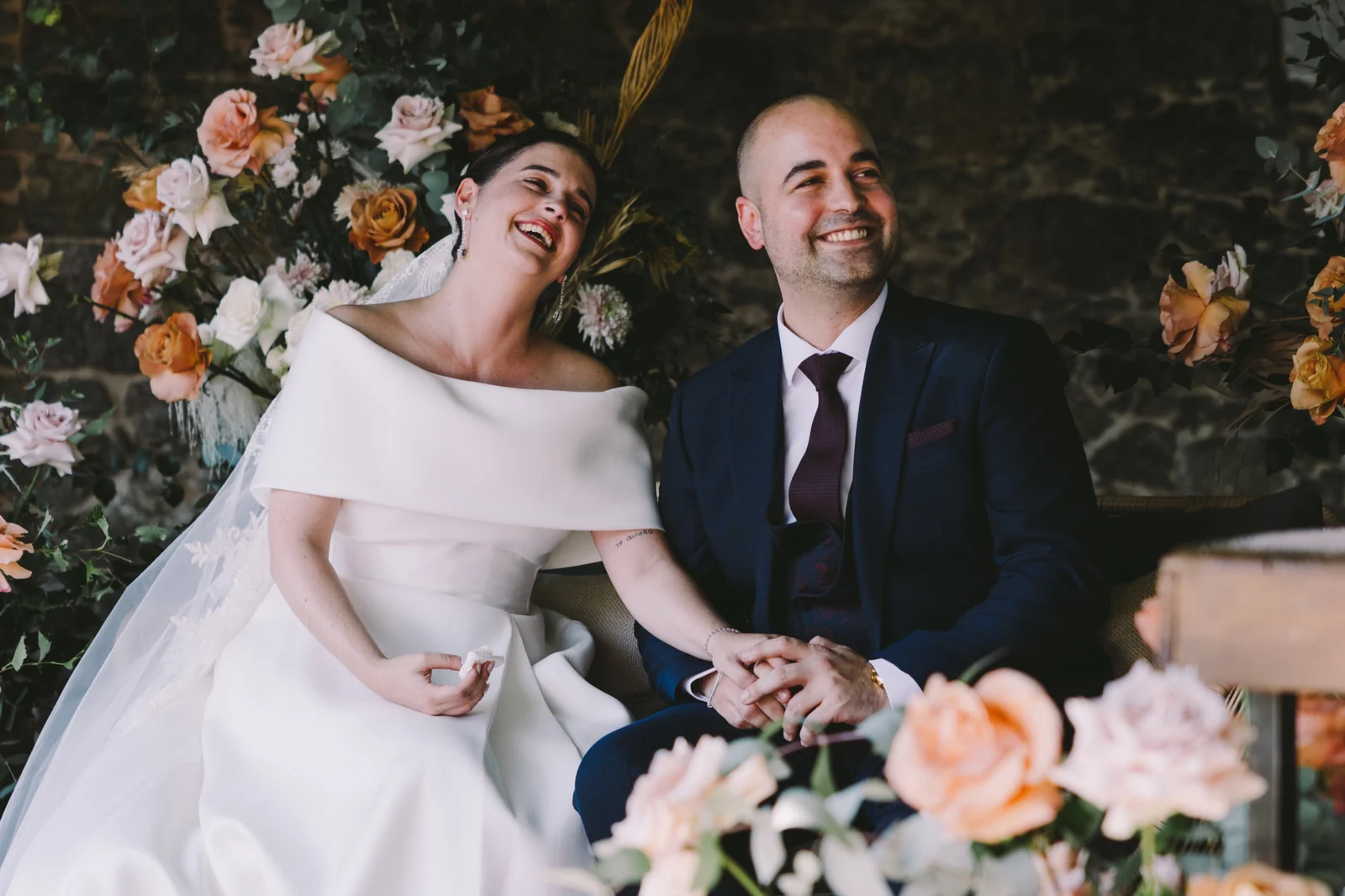 Novios sentados entre flores en el banquete