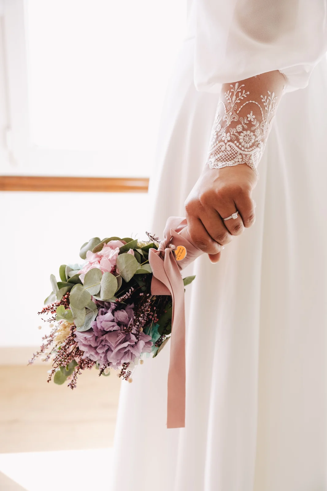 Novia sosteniendo el ramo junto a su vestido, fotografía de boda en Galicia