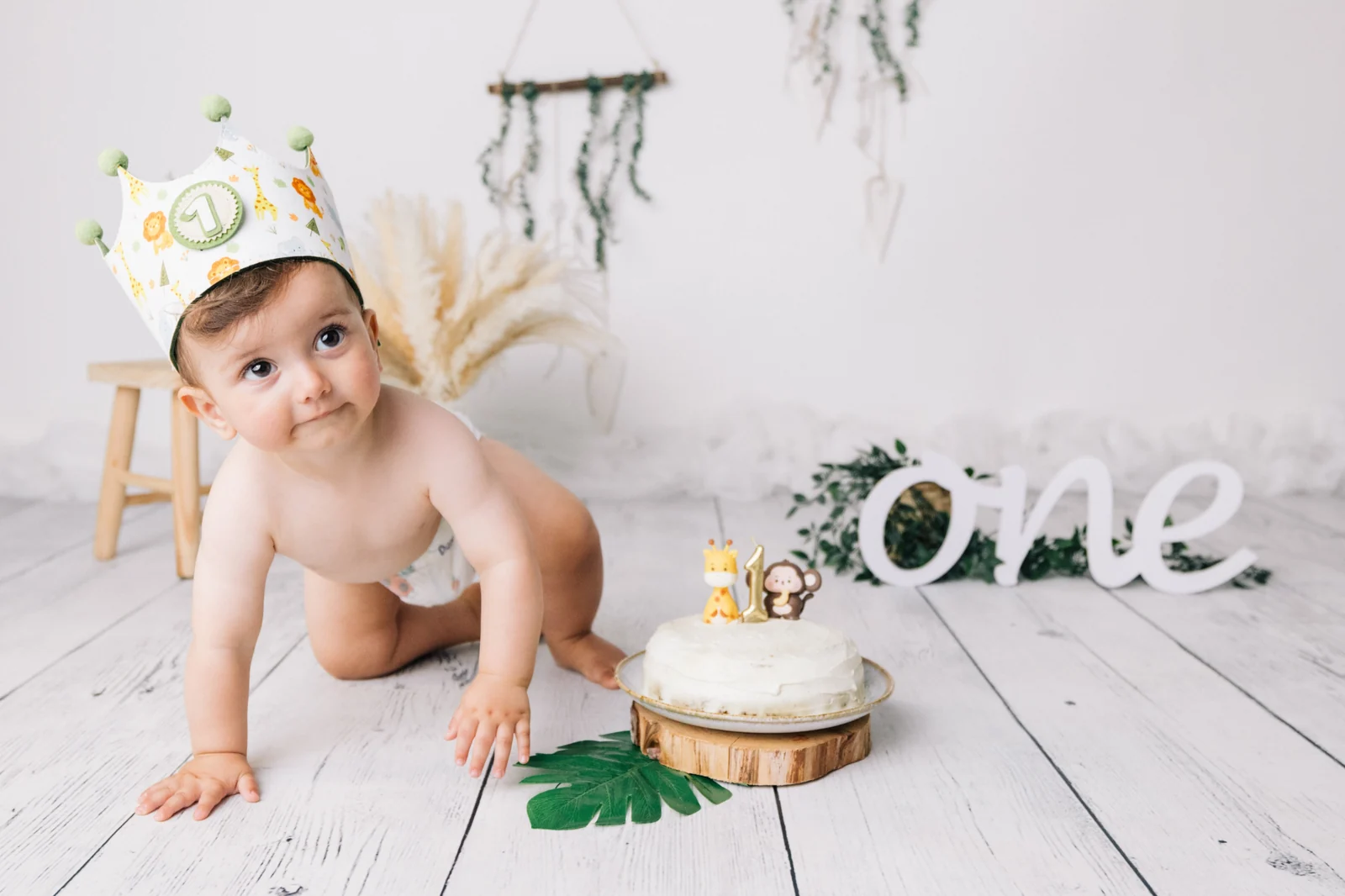 Sesión de cumpleaños en estudio en O Burgo, A Coruña — bebé con corona de tela junto a una tarta y el rótulo one